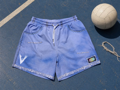 JORTS laid flat on a backyard volleyball court